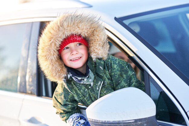 Menino feliz no carro durante o inverno. Foto de alta qualidade