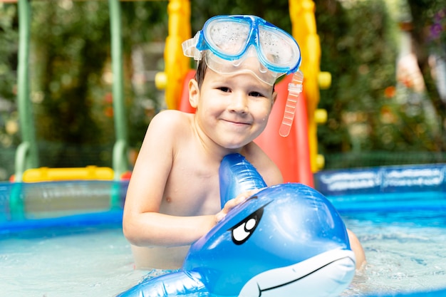 Menino feliz rindo da criança se divertindo em uma piscina