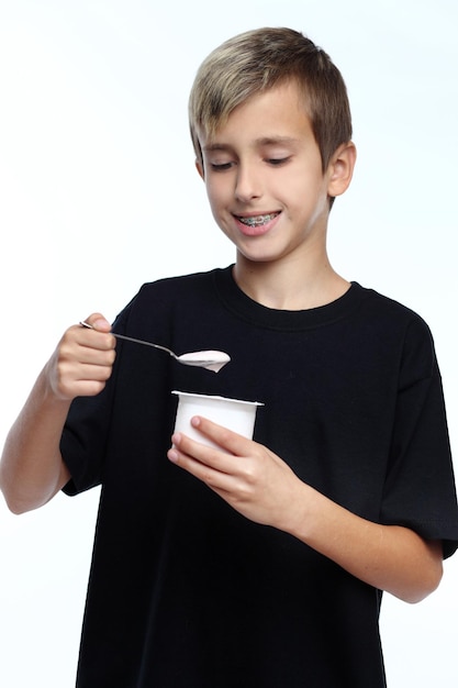 Menino feliz saudável comendo iogurte