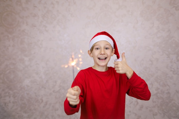 Menino feliz usando chapéu de Papai Noel e segurando um diamante, véspera de ano novo