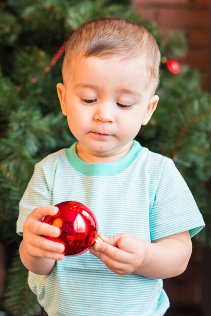 Menino fofo com bolas de natal