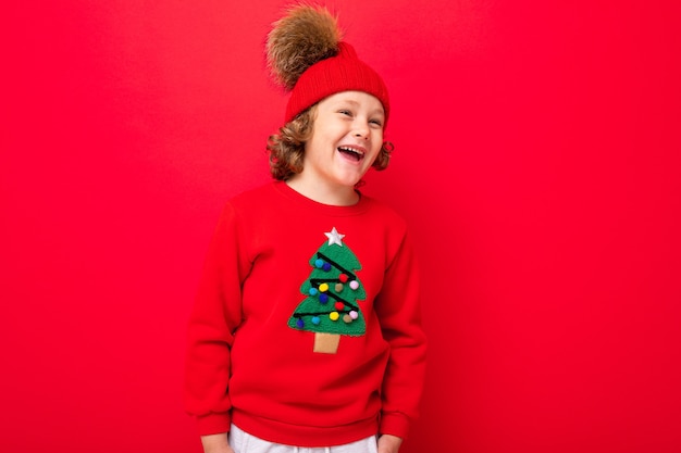 Menino fofo com um suéter de Natal e um chapéu