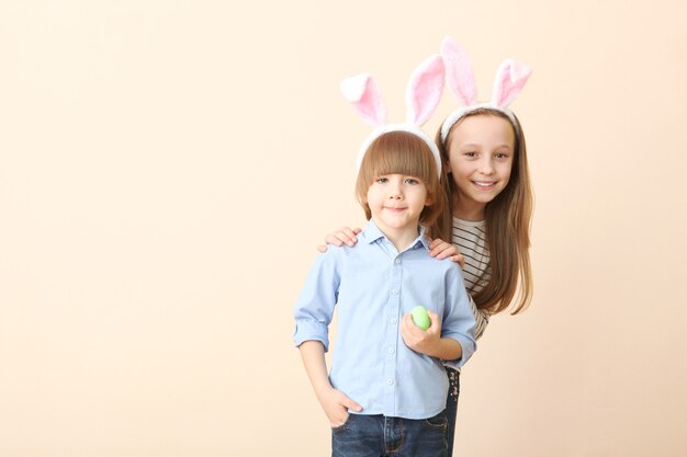 Menino fofo e menina com orelhas de coelho e uma cesta de Páscoa