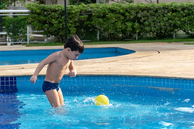 Menino fofo relaxando na piscina