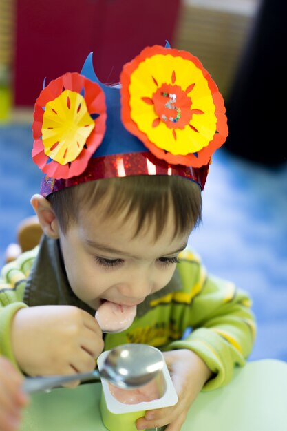 Menino fofo tendo festa de aniversário no jardim de infância