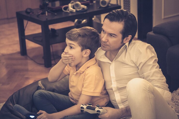 Foto menino incrédulo jogando videogames com seu pai e se divertindo em casa