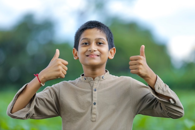 Menino indiano / asiático mostrando o polegar para cima
