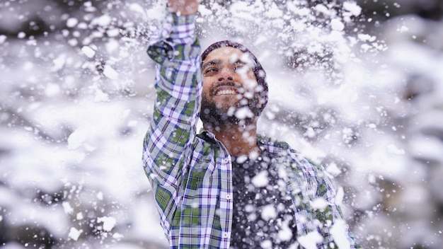 Menino indiano curtindo e brincando com neve durante a queda de neve do inverno