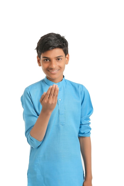 Menino indiano em roupas tradicionais e dando expressão de mão em fundo branco