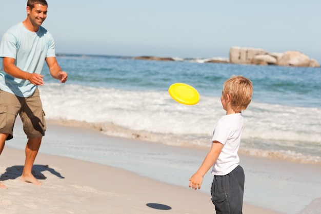 Menino jogando frisbee com seu pai