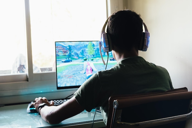 Menino jogando jogo no computador em casa