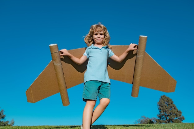 Menino jogando lá fora no céu azul menino piloto com jetpack de brinquedo menino jogando com avião de brinquedos