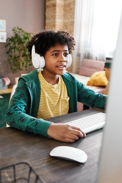 Menino jogando no computador durante o lazer em casa