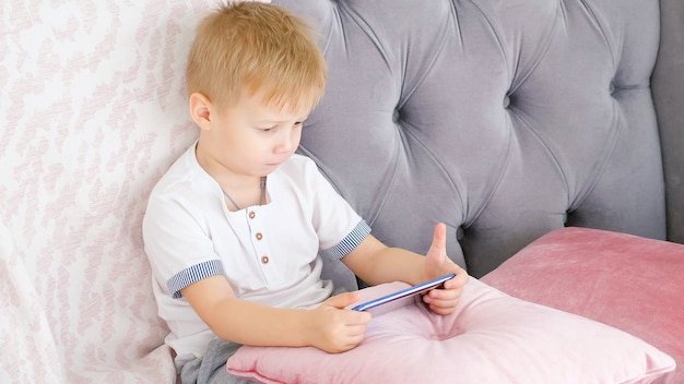 Menino jogando no sofá para smartphone