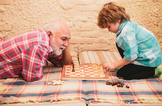 Foto menino jogando xadrez com seu avô hobbis de xadrez avô com neto jogando xadres