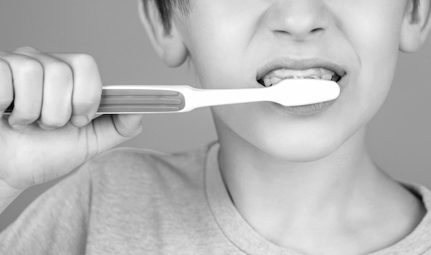 Menino limpando os dentes Higiene dental Criança feliz escovando os dentes Preto e branco