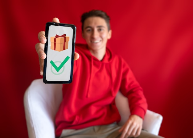 Menino lindo fazendo compras de Natal online com smartphone móvel