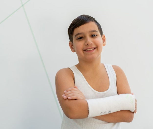 Menino mantém braço quebrado em gesso, braço de gesso, acidente em casa, lesão, conceito de trauma. foto de alta qualidade