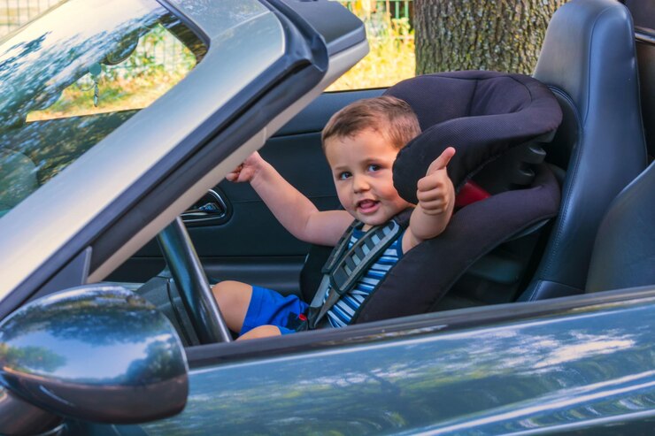 Foto menino mostrando o polegar enquanto está sentado no carro