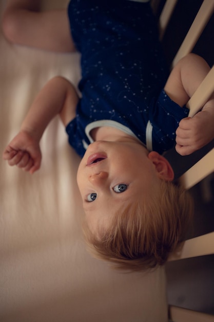 Menino muito fofo deitado de costas na cama Conceito de crescimento e desenvolvimento do bebê sono do bebê