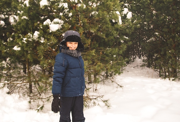 Menino na floresta de inverno fica