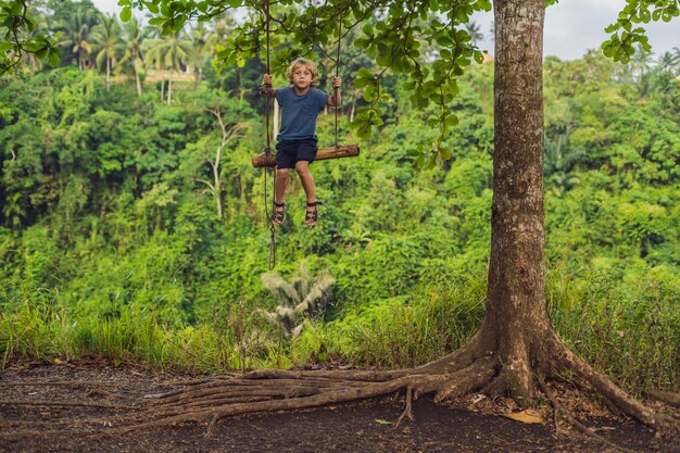 Menino no balanço no Campuhan Ridge Walk em Ubud, Bali.