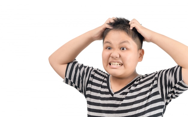 Menino obeso coça o cabelo, isolado no fundo branco,