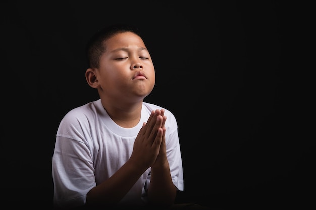 Menino orando a deus em casa