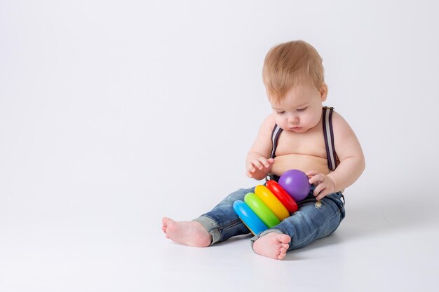 Menino pequeno com brinquedo em fundo branco