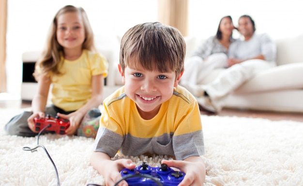 Menino pequeno jogando videogame com sua irmã