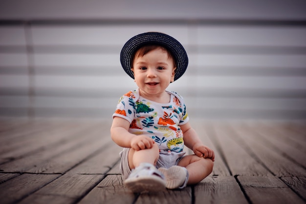 Foto menino pequeno sentado no chão de madeira