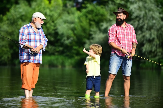 Menino pescando no rio com o pai e o avô