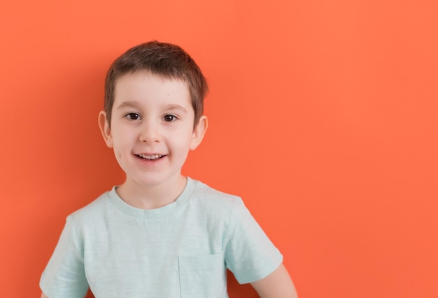 Menino pré-escolar em um fundo laranja