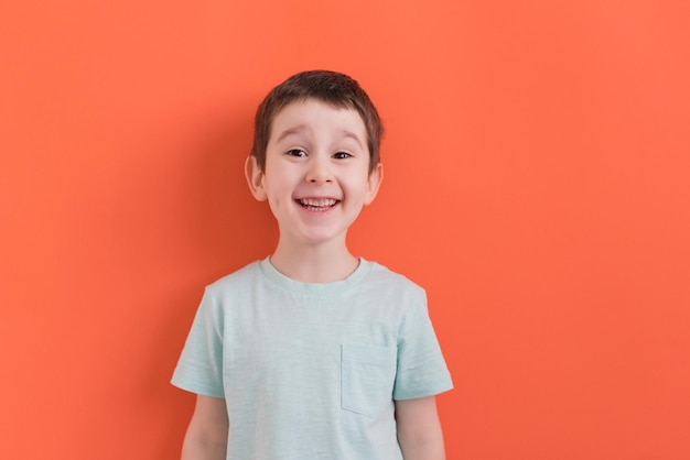 Menino pré-escolar em um fundo laranja