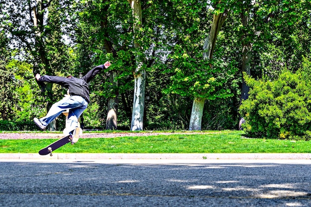 Menino pulando com skate no parque retiro em Madrid, Espanha