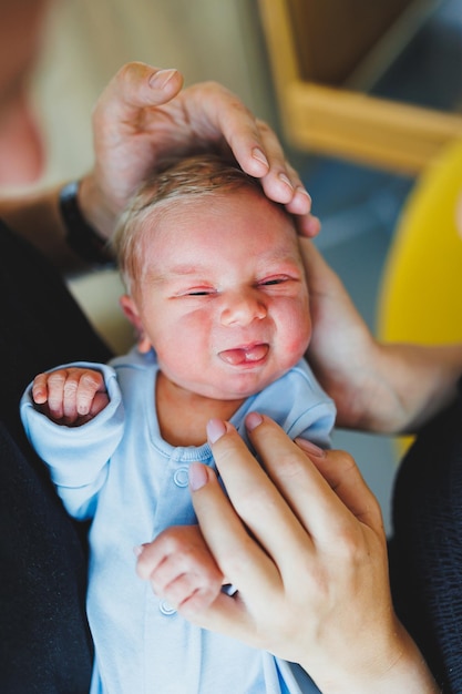 Foto menino recém-nascido nos braços de sua mãe e pai deitados em seus braços closeup vista superior jovens pais seguram seu bebê estilo de vida saudável paternidade