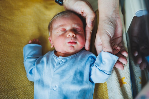 Menino recém-nascido nos braços de sua mãe e pai deitados em seus braços closeup vista superior Jovens pais seguram seu bebê Estilo de vida saudável Paternidade