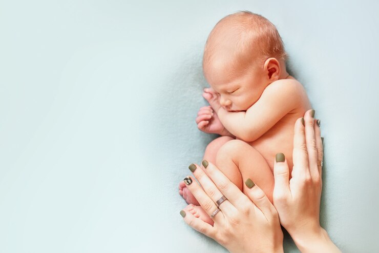 Foto menino recém-nascido nu com as mãos de mães dormindo no azul