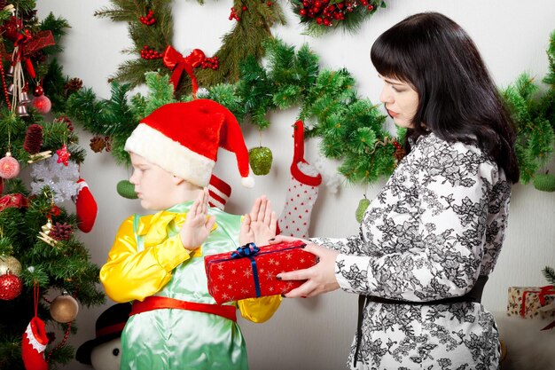 Menino recusando a caixa de presente de Natal da mãe