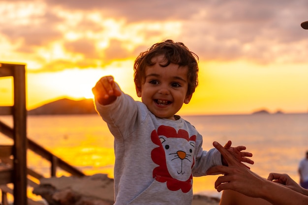Menino rindo ao pôr do sol na praia de Cala Comte, na ilha de Ibiza Balearic
