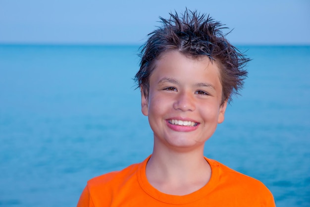 Menino rindo feliz na praia do mar