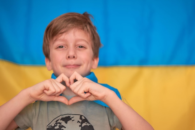 Foto menino segurando nas mãos crianças de bandeira amarela azul ucraniana apoiam a ucrânia mostrando o coração