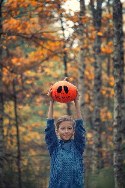 Menino segurando uma abóbora de halloween