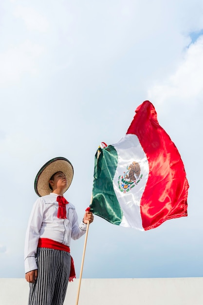 Foto menino segurando uma bandeira do méxico