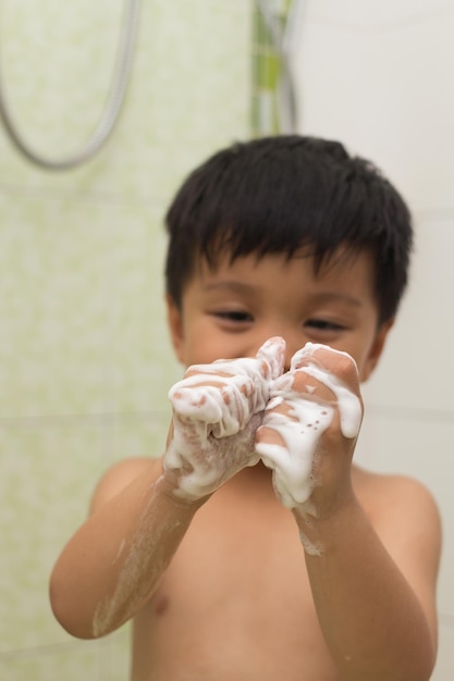 Foto menino sem camisa tomando banho na casa de banho