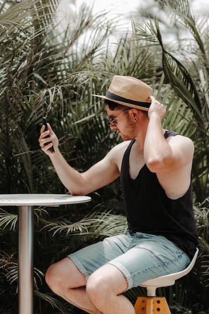 Menino sentado em um banquinho olhando para o celular