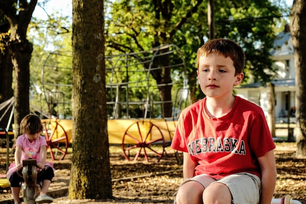 Menino sentado no playground