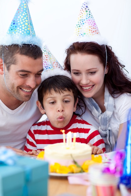 Menino soprando velas no dia do seu aniversário