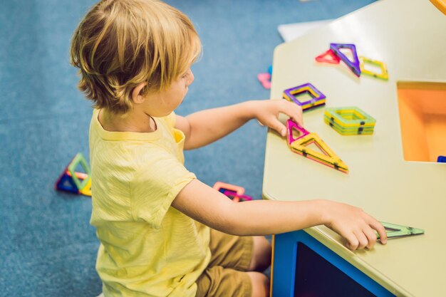 Menino sorridente brincando com brinquedo magnético