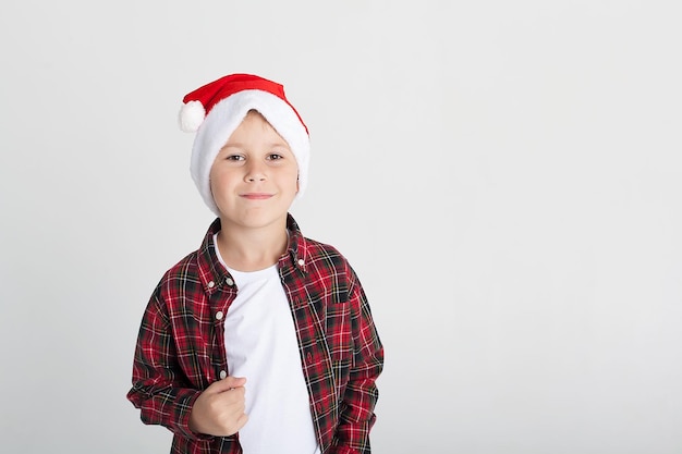 Menino sorridente com chapéu de Papai Noel com caixa de presente isolada em branco